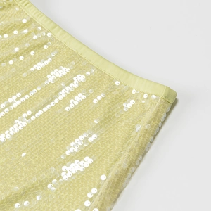 Vue macro détaillée du tissu en maille à paillettes jaunes avec broderie de paillettes blanches