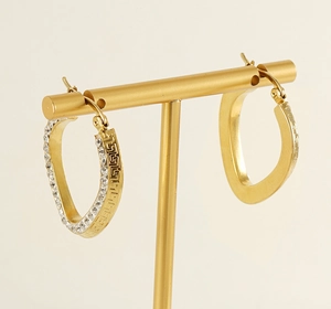 Close-up of gold titanium steel hoops with greek key pattern and crystal inlay details