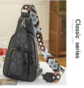 Detail view of black leopard print crossbody bag with colorful geometric woven strap