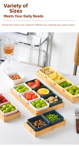 Close-up of colorful ceramic snack bowls on a bamboo tray set on a marble table