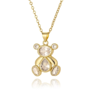 Macro detail of a golden bear pendant necklace featuring sparkling clear zircon stones