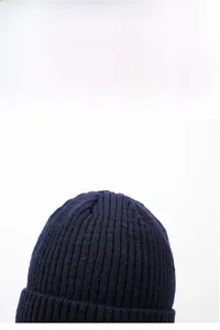 Detail of navy blue thick knit beanie showing textured rib pattern and warm fabric quality