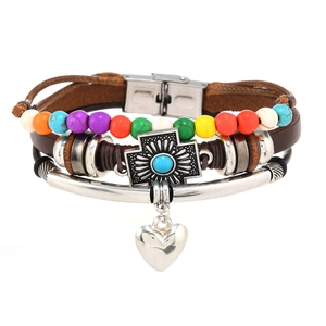 Detail of leather multi-layer bracelet featuring turquoise cross and silver heart charms