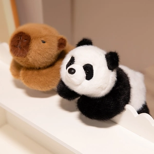 Soft plush panda and capybara stuffed animals lying on a cozy white display shelf