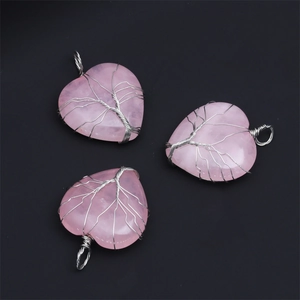 Three pink quartz heart pendants with silver wire-wrapped tree of life on black background