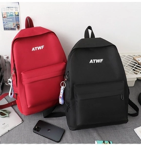 Detail of red and black waterproof backpacks with ATWF logo on checkered surface