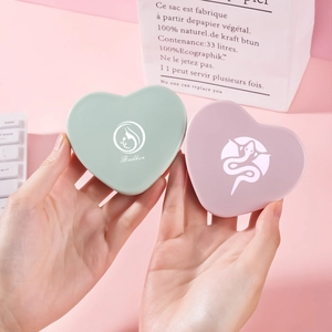 Portable heart-shaped folding makeup mirror in mint green and smoky pink colors
