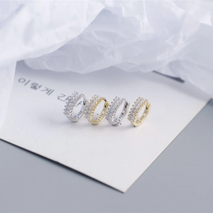 Macro shot of S925 sterling silver ear cuffs with rectangular zircon in gold and silver