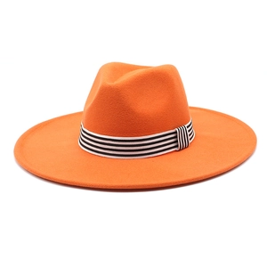 Close-up of orange wool fedora hat featuring a black and white striped ribbon band