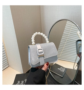 Detail of silver glitter mini square bag with elegant faux pearl handle and metal chain