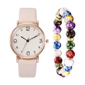 Detail of rose gold quartz watch with pink leather strap and colorful beaded bracelet set