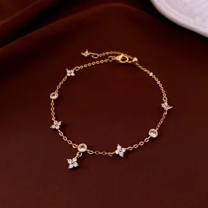 Gold plated four-leaf flower bracelet with zircon stones on dark brown velvet
