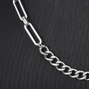 Detailed macro view of silver stainless steel paperclip chain and Cuban link splice design