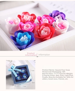 Detailed view of four soap flower roses in a 11x11x5cm transparent gift box with ribbon
