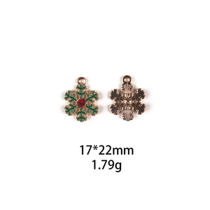 Detail of green snowflake DIY charm with red rhinestones measuring 17x22mm