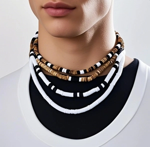 Close-up of bohemian layered necklaces with coconut shell and white tubular beads on a male model