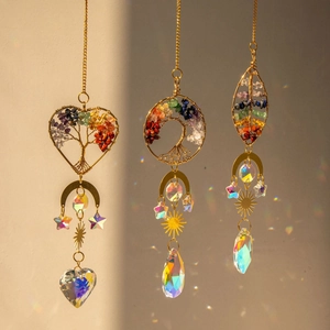 Brass tree of life suncatcher with crystal prisms and moon star charms hanging in sunlight