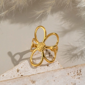 Eleganter goldener Blumenring mit hohl-fünfblättrigem Design auf Naturstein
