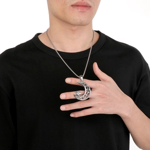 Detail showing vintage silver angel wings pendant with hollow moon and star patterns