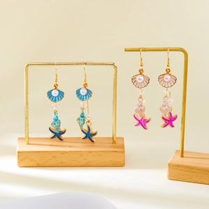 Detail of seashell and starfish tassel drop earrings in blue and pink tones
