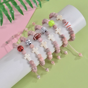 Pink stone bead sports bracelets with ball charms and cross beads on display stand