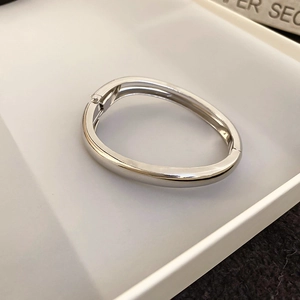 Detail view of silver water drop open cuff bracelet with a polished metallic finish