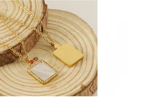 Detail of gold December birthstone necklace with shell inlay and halo of crystals