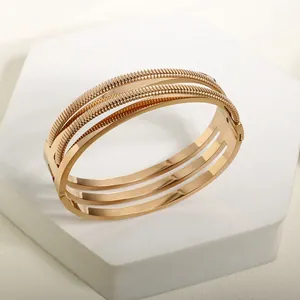 Macro shot of 18K rose gold-plated bangle with triple layers of twisted and polished textures