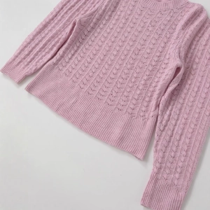 Pink crewneck long sleeve knit sweater featuring intricate hollow crochet and ribbed trim