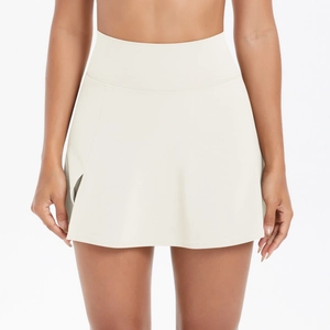 Dettaglio della gonna da tennis bianco crema a vita alta con spacco laterale e tessuto elastico