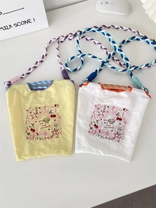 Détail du mini sac en tissu oxford avec broderie rouge et bandoulière en corde tressée