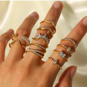 Close-up of gold bohemian stacking rings with cubic zirconia on silk background