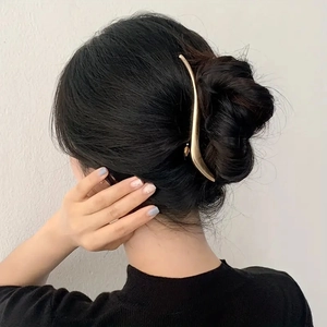 Model wearing a 13.2cm curved golden metal hair clip for elegant hairstyling