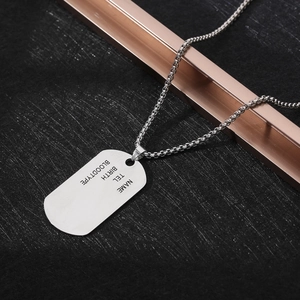 Macro detail of silver rectangle dog tag necklace with custom info engraving