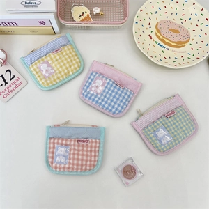 Close-up of quilted cotton coin purses with checkered patterns and clear card slots