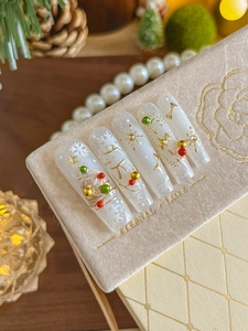 Detailed close-up of Christmas press-on nails with gold snowflakes and 3D beads decor