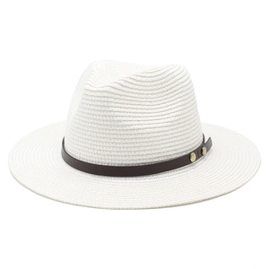 Detail of white woven sun hat featuring brown leather band and vintage gold rivets