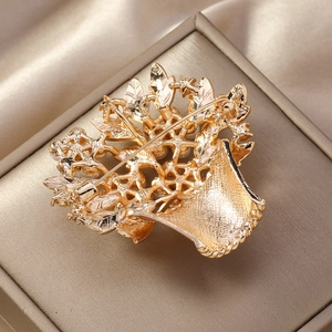 Macro shot of gold enamel flower basket brooch with metal pin on silk jewelry box