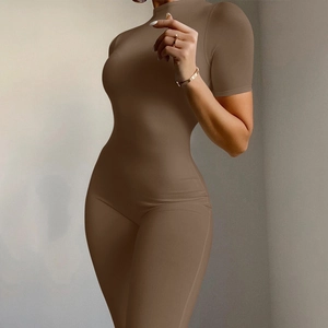 Detailed side view of slim fit brown short sleeve yoga jumpsuit showing body curves