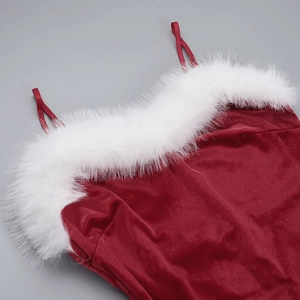 Detail van rode fluwelen kerstjurk met pluizige witte faux fur trim en dunne schouderbandjes