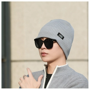 Close-up of gray ribbed knit beanie with brand label and textured fabric detail