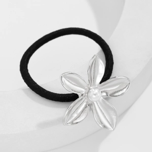 Detail of silver flower hair tie with faux pearl on white minimalist background