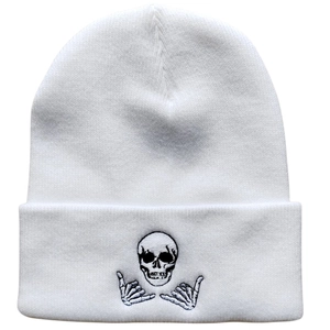 White knit beanie featuring black embroidered skeleton skull and Shaka hand gesture design