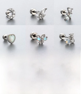 Detailed close-up of surgical steel ear studs with zircon butterflies and opal accents