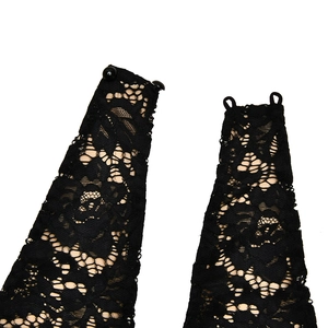 Détail de bretelles dos nu en dentelle noire avec motifs et fermoirs à boutons