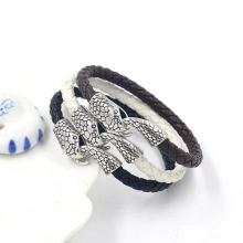 Three braided leather bracelets in black, white and brown with silver fish head clasps