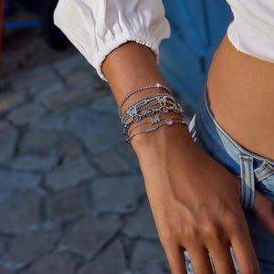 Luxe layered butterfly bracelet set with pink zircons and M pendant on model wrist