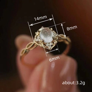 Elegante gouden ring met maansteen en klaverontwerp met geweven ringband