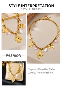 Detail view of gold-plated chunky chain necklace featuring floral and pearl pendants