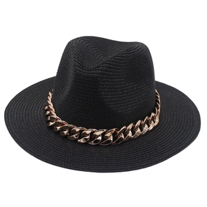 Gros plan détaillé d'un chapeau Panama en paille noire avec chaîne en acrylique dorée
